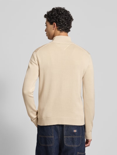 Männermodel trägt Slim Fit Troyer aus reiner Baumwolle von Tommy Jeans, unifarben, Feinstrick, gerippte Abschlüsse, Ganzkörperansicht Rückansicht.
