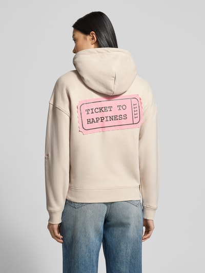 Frauenmodel trägt Oversized Sweatjacke mit Kapuze von Smith and Soul aus Baumwoll-Mix, mit Tunnelzug, Reißverschluss, Eingrifftaschen, gerippte Abschlüsse, beige-rosafarbene Details, Ganzkörperansicht Rückansicht.