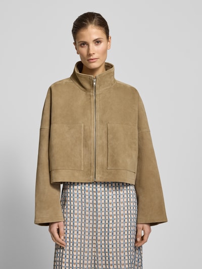 Frauenmodel trägt Relaxed Fit Lederjacke mit Stehkragen von Drykorn im sandfarbenen Leder-Mix mit aufgesetzten Eingrifftaschen, Reißverschluss, Ganzkörperansicht von vorne.