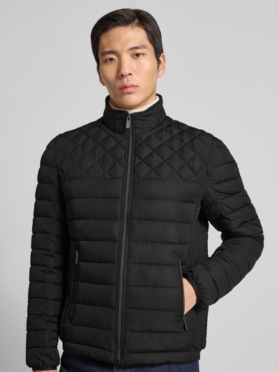 Männermodel trägt Slim Fit Steppjacke mit gefüttertem Kragen von Christian Berg Men in Schwarz, Reißverschlusstaschen, Nahaufnahme Oberkörper.