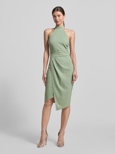 Kobiece modelka nosi Slim Fit Kleid mit Stehkragen od Lipsy, elastyczna mieszanka materiałów, asymetryczny krój, stójka, bez rękawów, marszczenia, długość tyłu w rozmiarze 36: 105 cm, szerokość w rozmiarze 36: 34 cm, kolor jasny zielony, całkowity widok z przodu.