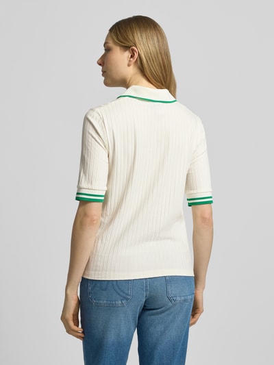 Vrouwenmodel draagt Regular Fit Poloshirt uit viscosemix van Marc Cain, crèmekleur met groene accenten, comfortabele pasvorm, rugaanzicht gehele lichaam.