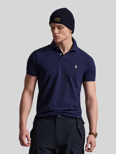 Männermodel trägt Regular Fit Poloshirt aus reiner Baumwolle von Polo Ralph Lauren in Dunkelblau, unifarben, Logo-Detail, Ganzkörperansicht von vorne