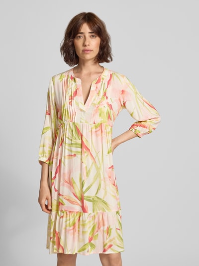 Frauenmodel trägt knielanges Tunikakleid mit V-Ausschnitt Modell 'Ma44gali' von ZABAIONE, florales Muster, 3/4-Arm, Ganzkörperansicht von vorne.