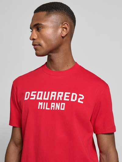 Männermodel trägt Cool Fit T-Shirt aus reiner Baumwolle von Dsquared2 in Rot mit weißem Statement-Print, Nahaufnahme Oberkörper.