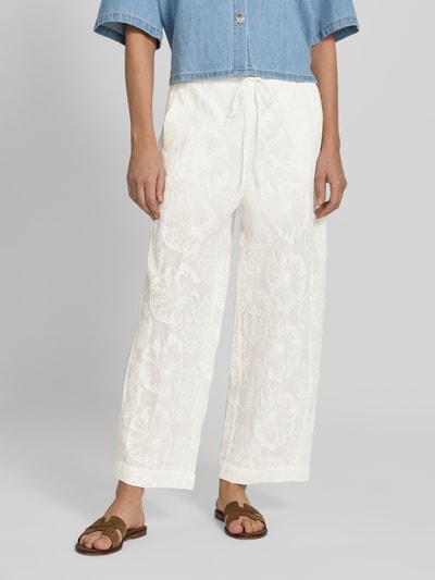 Frauenmodel trägt Wide Fit Stoffhose mit floralem Allover-Design von Mango aus Reine Baumwolle, weiß, Elastischer Bund mit Tunnelzug, Ganzkörperansicht von vorne.