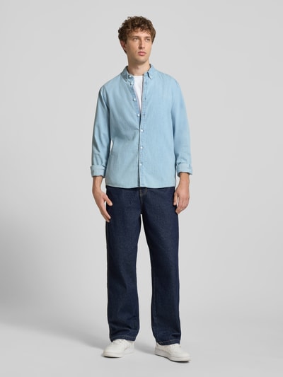 Männermodel trägt Regular Fit Freizeithemd in Denim-Optik von REVIEW, reine Baumwolle, Button-Down-Kragen, Ganzkörperansicht von vorne.