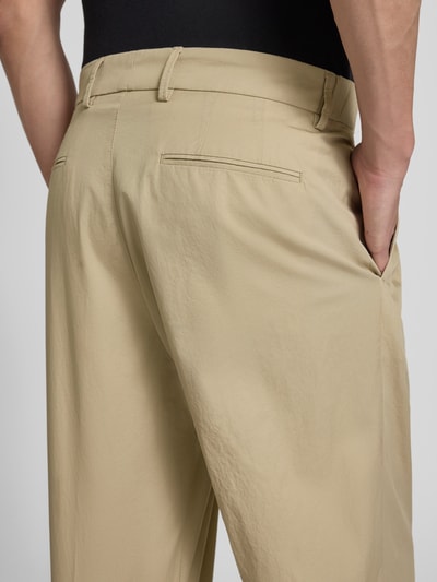 Männermodel trägt Stoffhose mit Biesen und Eingrifftaschen Modell 'LEEK' von Drykorn in Beige aus Reine Baumwolle, Detailaufnahme Rückansicht