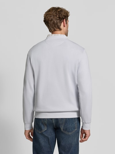 Männermodel trägt Sweatshirt mit Label-Patch von Scotch & Soda aus bawełna, luźny krój, okrągły dekolt, prążkowane wykończenia, Długość tyłu w rozmiarze M: 64 cm, Długość rękawów w rozmiarze M: 64 cm, Ganzkörperansicht Rückansicht