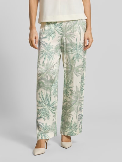 Frauenmodel trägt Regular Fit Weite Hose aus reiner Viskose von s.Oliver BLACK LABEL mit grünem Palmenmuster, Nahaufnahme Unterkörper.