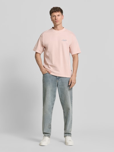 Männermodel trägt Regular Fit T-Shirt aus reiner Baumwolle Modell 'SURFWASH' von BOSS Orange, Optik: Unifarben, Label-Print, Rundhals, Kurzarm, Materialverarbeitung: Jersey, Ganzkörperansicht von vorne.