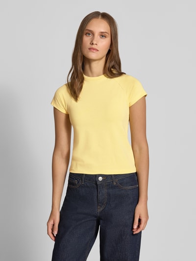 Frauenmodel trägt T-Shirt mit Raglanärmeln Modell 'KATINKA' von NOISY MAY®, gelb, eng anliegend, Rundhalsausschnitt, Ganzkörperansicht von vorne.