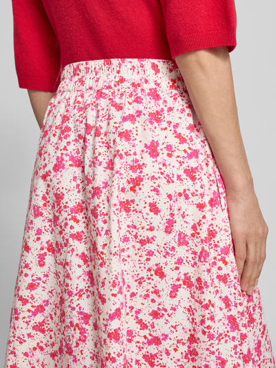 Vrouwenmodel draagt Glockenrock met elastischem Bund van YAS, A-lijn, midirok, brede zoom, witte stof met roze en rode spetters, detailopname rugaanzicht.
