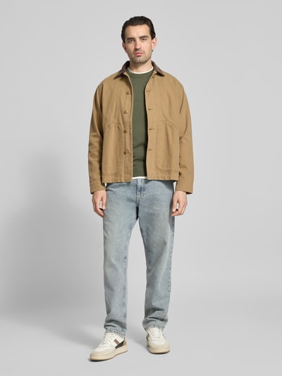 Männermodel trägt Regular Fit Strickpullover aus reiner Baumwolle von Tom Tailor in Unifarben Melange-Optik, Ganzkörperansicht von vorne.