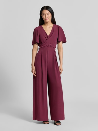 Frauenmodel trägt Jumpsuit mit Stoffgürtel von Rinascimento in Bordeaux, taillierte Passform, V-Ausschnitt, Material-Mix, Ganzkörperansicht von vorne.