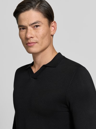 Männermodel trägt schwarzen Strickpullover mit Viskose-Anteil Modell 'MANICA LUNGA' von MARKUP, glatte Textur, Nahaufnahme Oberkörper.