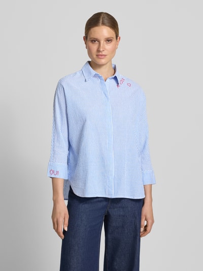Frauenmodel trägt Relaxed Fit Bluse mit Stitchings und 3/4-Arm von Oui aus reiner Baumwolle, feine blaue Streifen, Hemdblusenkragen, Ganzkörperansicht von vorne.