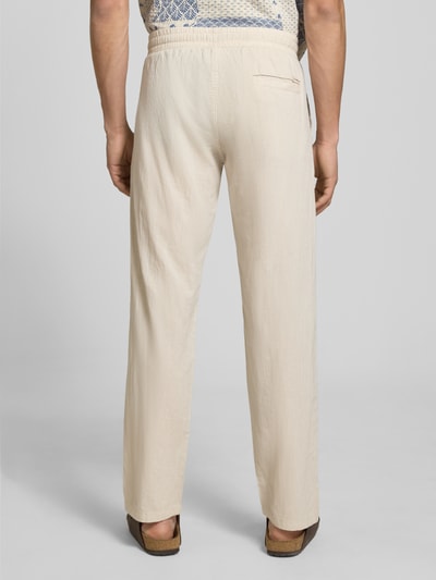 Męski model nosi Hose aus Baumwoll-Leinen-Mix Modell 'KANE' od Jack & Jones, beżowy kolor, krój regular fit, elastyczny pas, szerokość w rozmiarze M: 41 cm, długość nogawki od wewnątrz w rozmiarze M: 81 cm, widok całej sylwetki z tyłu.