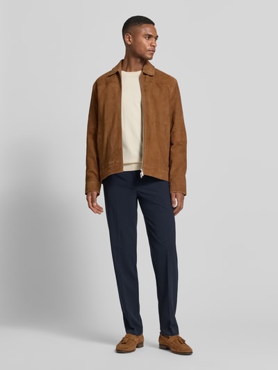 Männermodel trägt Slim Fit Stoffhose mit Viskose-Anteil von Lindbergh in Dunkelblau, mit Bügelfalte, Gesäßtaschen, Eingrifftaschen, Haken- und Reißverschluss, Elastischer Material-Mix, Bundweite 37 cm, Innenbeinlänge 80 cm, Ganzkörperansicht von vorne.