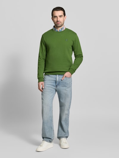 Mannenmodel draagt Sweatshirt met ronde hals van Scotch & Soda in groen, puur katoen, regular fit, labelstitching, volledige lichaamsvoorzijde.