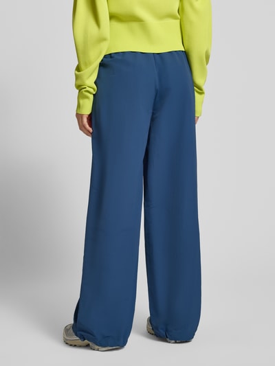 Frauenmodel trägt Nylon-Ballonhose im 90s-Stil - curated by Tinvcb von Tinvcb in Blau mit Relaxed Fit, elastischem Bund, Eingrifftaschen, Ganzkörperansicht Rückansicht.