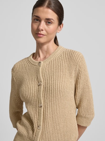 Modelka nosi Strickshirt mit 1/2-Arm Modell 'Donousa' von OPUS, krój regular fit, okrągły dekolt, listwa guzikowa, długość tyłu 60 cm, długość rękawów 36 cm, beżowa dzianina, widoczna faktura, zbliżenie na górną część ciała, przód