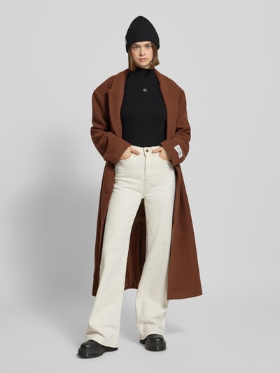 Vrouwenmodel draagt Turtleneck-Pullover met Label-Detail van Calvin Klein Jeans, zwart, mix van katoen en elastaan, nauwsluitend model, opstaande kraag, ruglengte maat S 56 cm, detailopname bovenlichaam vooraanzicht.