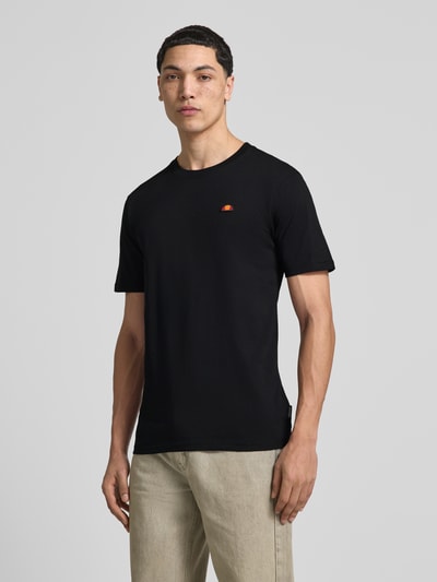 Männermodel trägt T-Shirt mit Label-Stitching Modell 'CASSICA' von Ellesse in Schwarz aus Reine Baumwolle, Gerader-Schnitt, Nahaufnahme Oberkörper.