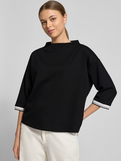 Frauenmodel trägt schwarzen Relaxed Fit Pullover mit Viskose-Anteil Modell 'Utalba' von Someday, Halbarm, Stehkragen, Ganzkörperansicht von vorne.