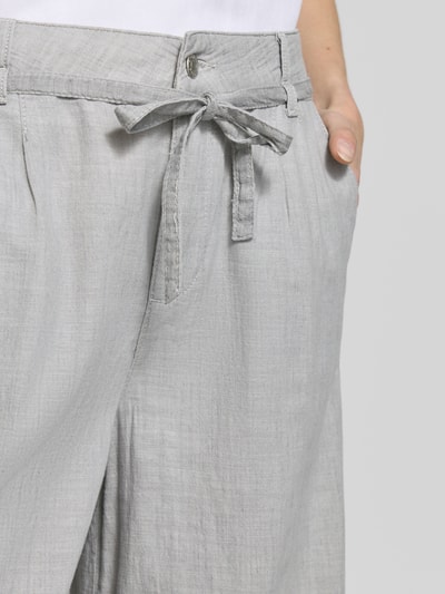 Frauenmodel trägt Wide Fit Stoffhose mit Bügelfalten Modell 'Livia' von Angels aus Reine Baumwolle, Eingriffstaschen, Knopf-Reißverschluss, Nahaufnahme Oberkörper.