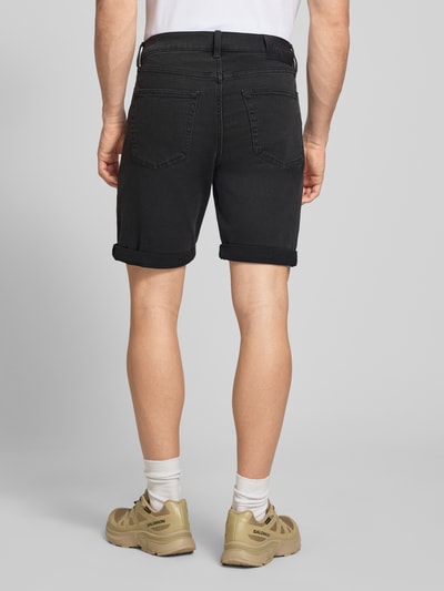Männermodel trägt Slim Fit Jeansshorts aus Baumwoll-Mix Modell 'CK ESSENTIAL BLACK' von Calvin Klein Jeans, Denim-Optik, Label-Patch, 5-Pocket-Design, Knopf und verdeckter Reißverschluss, Gürtelschlaufen, schwarze Farbe, glatte Textur, für Herren, Ganzkörperansicht Rückansicht.