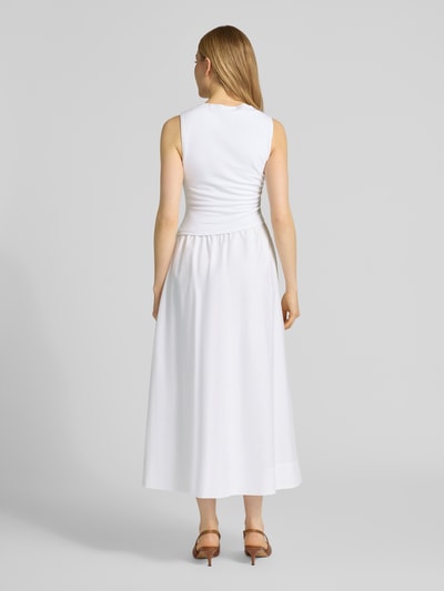 Modelka kobieta ma na sobie białą sukienkę koktajlową w asymetrycznym kroju Cocktailkleid in asymmetrischem Design Modell 'Felicity' od Forever New, wykonana z mieszanki wiskozy i elastanu, krój dopasowany w talii, długość midi, 2-w-1, długość tyłu w rozmiarze 36: 133 cm, szerokość w rozmiarze 36: 39 cm, widok całej sylwetki od tyłu.
