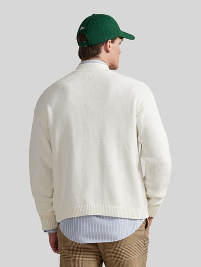 Männermodel trägt Regular Fit Strickjacke aus reiner Baumwolle von Polo Ralph Lauren in Creme, einfarbig, Strickstruktur, Ganzkörperansicht Rückansicht.