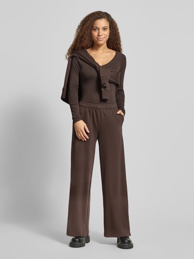Vrouwenmodel draagt Slim Fit Longsleeve met V-hals van Gina Tricot in bruin katoenmix, dames shirt met lange mouwen, ruglengte 48 cm, slim fit, V-hals. Ganzlichaamsaanzicht van voren.