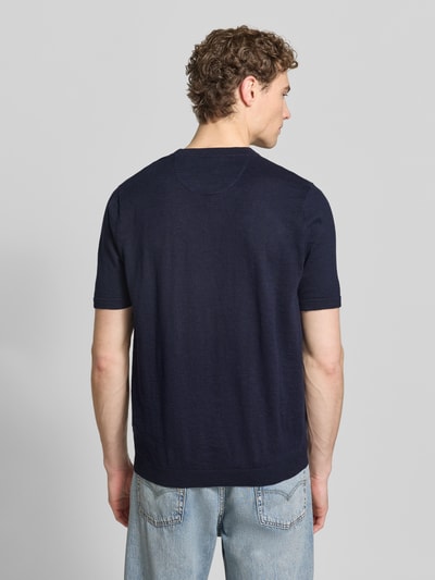 Mężczyznamodel nosi Regular Fit T-Shirt mit Leinen-Anteil in Strick-Optik od Fynch-Hatton, bawełniany miks z dodatkiem lnu, krój regular fit, imitacja dzianiny, wyhaftowane logo, elastyczne wykończenia, długość tyłu w rozmiarze M: 70 cm, widok całej sylwetki z tyłu.