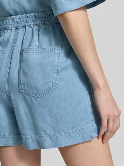 Frauenmodel trägt Shorts aus Lyocell in Denim-Optik von Rich & Royal, hellblaue Farbe, sichtbare Gesäßtaschen, elastischer Bund, Detailaufnahme Rückansicht. Regular Fit, reine Lyocellqualität, strukturierte Oberfläche, Bundweite 36 cm, Innenbeinlänge 40 cm.