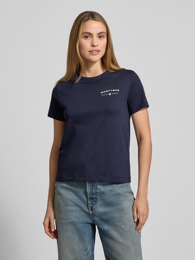 Kobiece model nosi T-Shirt z nadrukiem logo i okrągłym dekoltem od Gant, granatowy kolor, czysta bawełna, Regular Fit, ujęcie przód, zbliżenie na górną część ciała.