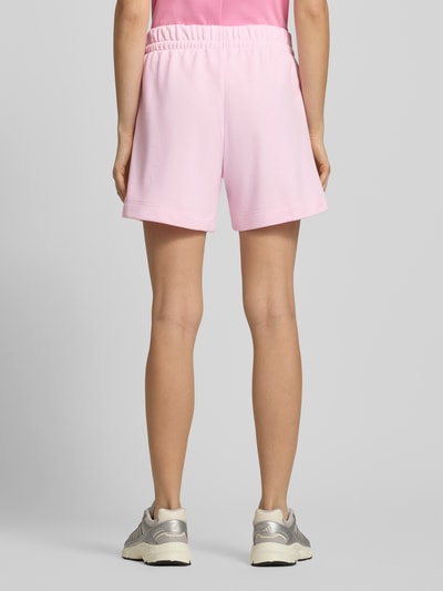 Vrouwenmodel draagt Shorts met elastische tailleband en trekkoord van adidas Sportswear in lichtroze, katoenmix, rugaanzicht