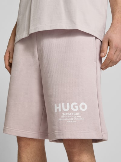 Männermodel trägt Loose Fit Sweatshorts aus reiner Baumwolle Modell 'Nomario' von Hugo Blue, Optik: Unifarben, Label-Schriftzug, Sweat, seitliche Eingrifftaschen, Nahaufnahme Oberschenkel.
