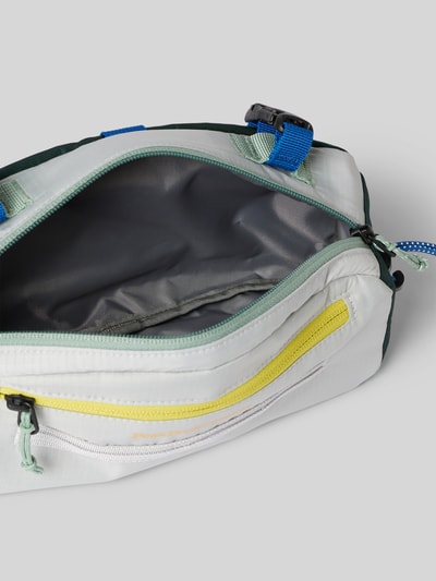 Produktfoto, Fahrradtasche mit Label-Detail von PEAK PERFORMANCE in Weiß mit Hauptfach, Nebenfach mit Reißverschluss, verstellbare Riemen, Maße 26 cm Breite, 14 cm Länge, 5 cm Tiefe, Riemenlänge: 94 cm, glatte Textur mit farbigen Akzenten.