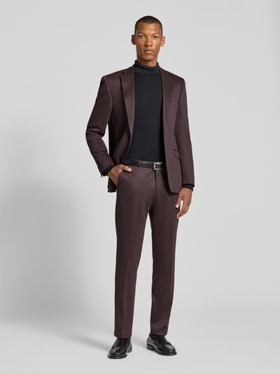 Männermodel trägt Slim Fit Anzug mit Stretch-Anteil von ROY ROBSON in Braun, kombiniert mit schwarzem Rollkragenpullover, Ganzkörperansicht von vorne.