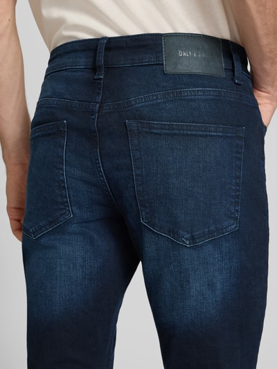 Männermodel trägt dunkelblaue Slim Fit Jeans aus Baumwoll-Mix Modell 'LOOM' von ONLY, Herren Slim Fit Jeans von ONLY & SONS, Nahaufnahme Rückansicht.