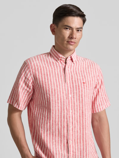 Männermodel trägt Regular Fit Freizeithemd mit Button-Down-Kragen von Fynch-Hatton aus Baumwolle-Leinen-Mix, vertikale Streifen, Logo-Stitching, Knopfleiste, Nahaufnahme Oberkörper, Rückenlänge 76 cm, Schulterbreite 45 cm, Ärmellänge 26 cm, Größe M.