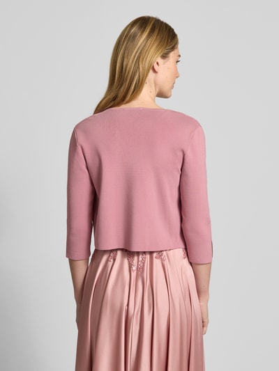 Frauenmodel trägt Bolero mit 3/4-Arm von Vera Mont, rosafarbener Viskose-Mix mit Stretch-Anteil, körpernahe Passform, offene Vorderseite, Rückseite. Ganzkörperansicht Rückansicht.