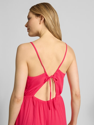 Frauenmodel trägt Midikleid aus Viskose mit tiefem Rückenausschnitt von ICHI in kräftigem Pink, schlichte Textur, Modell 'MARRAKECH', Spaghettiträger, Taillierter Schnitt, Rückenschnürung, Nahaufnahme Rückansicht.