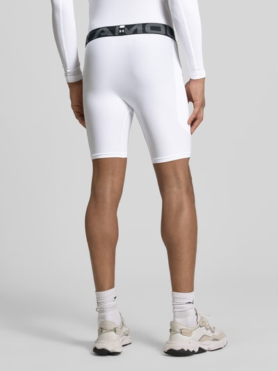 Männermodel trägt Shorts mit elastischem Logo-Bund von Under Armour aus weißem Material-Mix mit Stretch-Anteil, Körpernaher-Schnitt, Label-Print, Bundweite 37 cm, Innenbeinlänge 21 cm, Ganzkörperansicht Rückansicht.