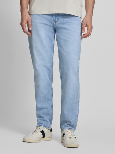 Männermodel trägt Tapered-Fit Herren Jeans aus reiner Baumwolle Modell 'HARLEM' von Tommy Hilfiger, helle Denim-Optik, Ganzkörperansicht von vorne.