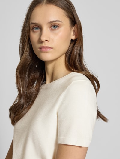 Frauenmodel trägt Strickshirt aus Viskose-Mix mit Rundhalsausschnitt von Review in Creme, glatte Struktur, Nahaufnahme Oberkörper. Regular Fit, Rippbündchen, Rückenlänge 50 cm, Ärmellänge 20 cm.