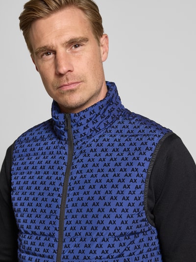 Mannermodel draagt Regular fit bodywarmer met vulling van eendendons en veren Model 'PIUMINO' van Armani Exchange, All-over logoprint, Nahaufnahme bovenlichaam. Ruglengte maat M: 67 cm, schouderbreedte: 46 cm, borstwijdte: 54 cm.