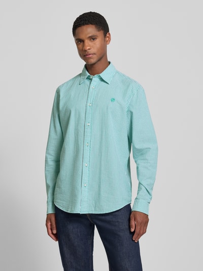 Männermodel trägt Regular Fit Freizeithemd mit Logo-Stitching von MCNEAL in grün-weiß, Streifenmuster, Baumwolle, Kentkragen, Knopfleiste, Ganzkörperansicht von vorne, Rückenlänge bei Größe M 69 cm, Schulterbreite 47 cm, Ärmellänge 66 cm.